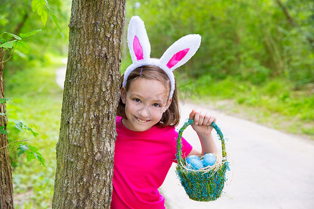 复活节女孩带着鸡蛋篮子和滑稽的兔子脸