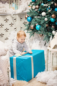蹒跚学步的男孩打开一个装有圣诞礼物的盒子