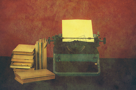 复古的旧报纸摄影照片_桌上有复古色彩书籍的旧打字机
