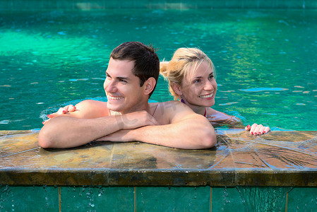 洗澡摄影照片_幸福的微笑夫妇在游泳池