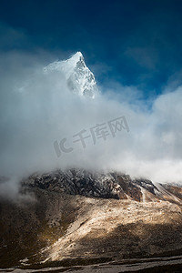喜玛拉雅摄影照片_Cholatse 6335 米山峰隐藏在云层中