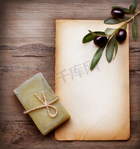 干奶酪的手工卡摄影照片_手工橄榄皂和白纸与橄榄枝在伍德