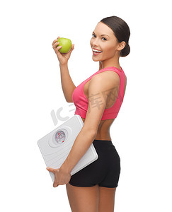 有体重秤和青苹果的运动型女人