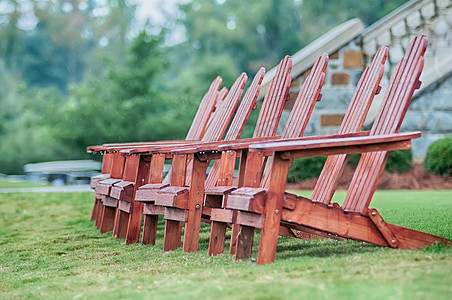 郁郁葱葱的绿色草坪上的两把木制阿迪朗达克椅
