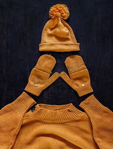 帽子上有绒球、手套、黄橙色毛衣