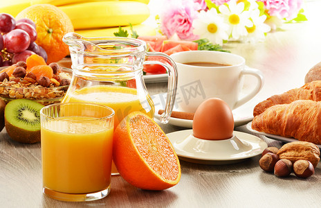 面包鸡蛋橙汁摄影照片_早餐用咖啡、橙汁、羊角面包、鸡蛋、蔬菜