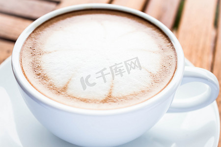一杯热咖啡摄影照片_在木桌上供应一杯热咖啡摩卡咖啡