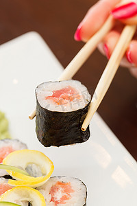 红色的筷子摄影照片_用筷子做寿司