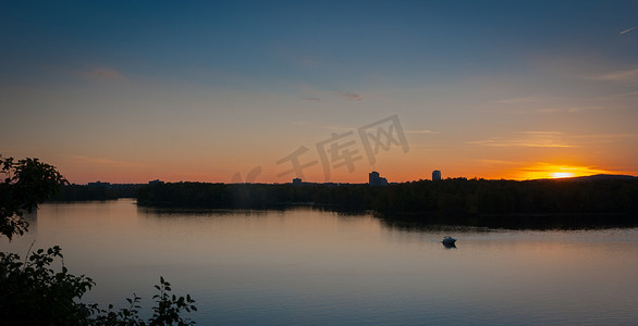 船在水中倒影摄影照片_五颜六色的晚上日落在河上。