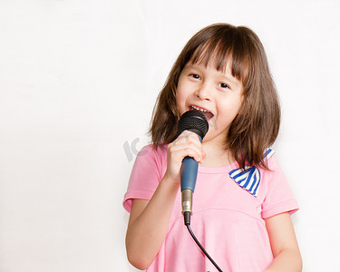话筒发言权摄影照片_亚洲儿童对着麦克风唱歌