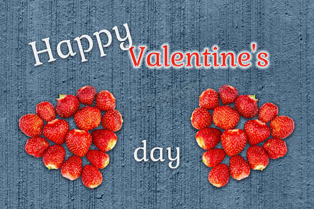草莓丁摄影照片_漂亮的情人节贺卡 — 用草莓做成的心，背景是格朗基混凝土质地，上面写着情人节快乐