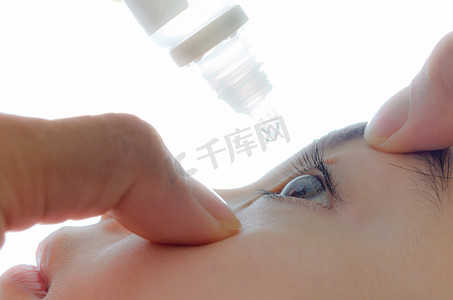 眼睛护理摄影照片_用眼药水护理眼睛。