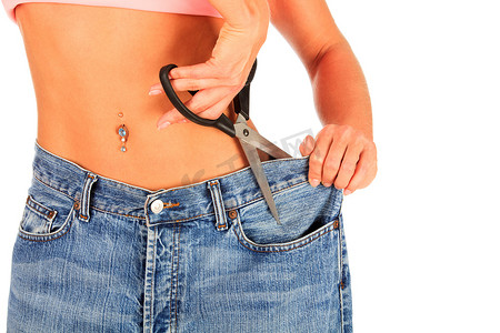肚子大的女人摄影照片_女人裁剪她的旧牛仔裤的尺寸。