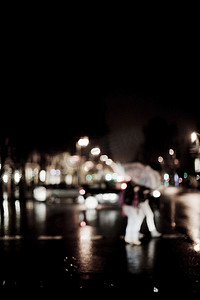 夜间雨中过马路的散焦人群