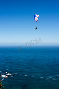 蓝天碧水摄影照片_蓝天碧水前飞翔的滑翔伞