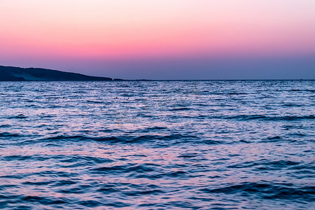 日落时拍摄的宽阔的大海风景照片，色彩艳丽