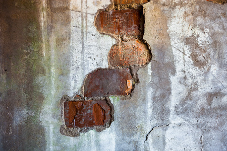 旧墙裂开的石膏中可见砖块