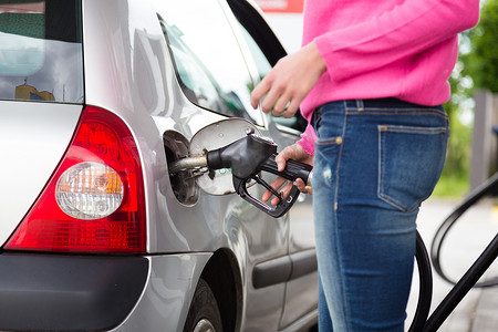 车加油摄影照片_女士在加油站的车里抽汽油。