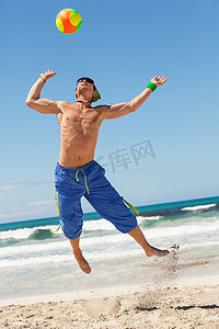 有魅力的年轻人在沙滩上打排球