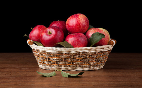 木桌上篮子里有很多苹果