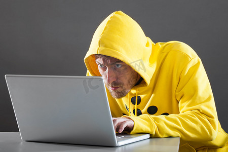 在互联网上工作的穿黄色夹克的男人