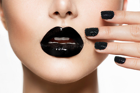 艺术嘴唇摄影照片_时髦的黑鱼子酱修指甲和黑嘴唇。