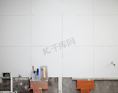 抹墙工具摄影照片_瓷砖白墙施工用抹子工具