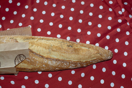 粉丝长方形摄影照片_红色和白色圆点织物上的长方形面包