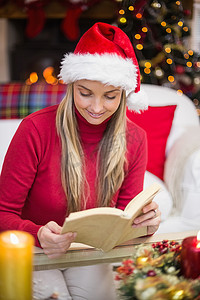 圣诞节时戴着圣诞帽的漂亮金发女郎在看书