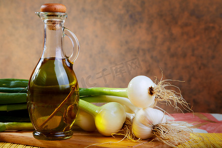 洋葱和大蒜摄影照片_洋葱和大蒜与橄榄油瓶