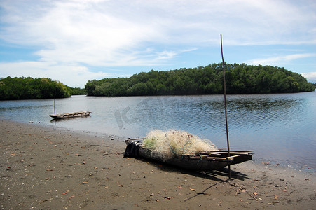 巴布亚新几内亚海滩上带渔网的独木舟