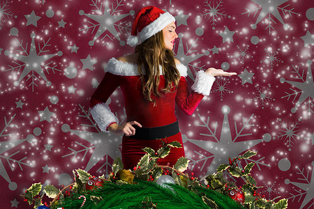 穿着圣诞老人服装的漂亮女孩伸出手的合成图像