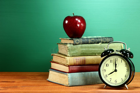 课本、苹果和学校桌上的时钟
