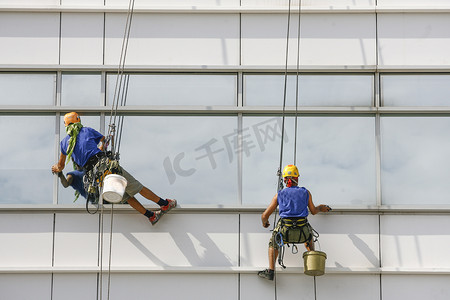 擦玻璃工人摄影照片_建筑上的窗户清洁工