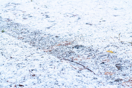 轮胎轨迹轮胎摄影照片_第一次降雪后，汽车轮胎在碎石路上的轨迹