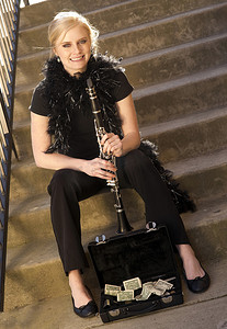 女街头艺人坐在带尖头的台阶上单簧管盒