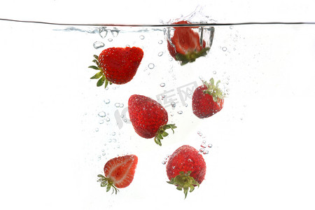 种植水果摄影照片_草莓落入飞溅的清水中