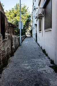 一条狭窄的城市街道，有石地板和古老的老式建筑