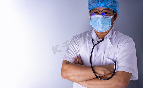 戴口罩、戴帽子的医生双臂交叉站立姿势的画像。