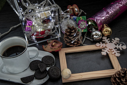 一杯咖啡加巧克力曲奇饼和圣诞装饰与空木框设计元素的工作。