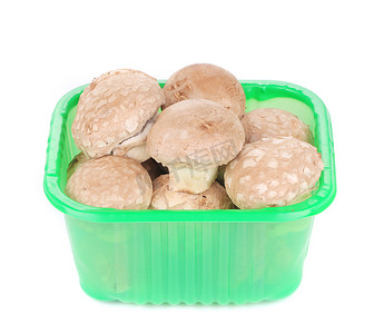 可食用塑料摄影照片_塑料盒中的棕色香菇。
