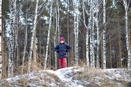 十几岁的男孩在积雪覆盖的树林中的画像。