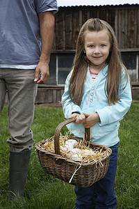 草原上被剪短的父亲拿着鸡蛋篮的可爱女孩的画像