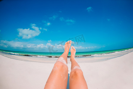 沙滩背景摄影照片_在白色沙滩背景海的女性脚
