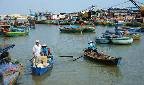 划木船的人摄影照片_在港口用木船运送人员和货物