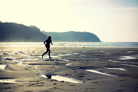 奔跑背摄影照片_在沙滩上奔跑的女孩