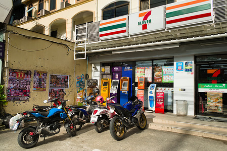 东南亚风光摄影照片_2019-11-05 / 泰国普吉岛 - 7-11 商店外停着摩托车。