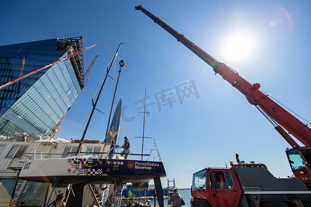 俄罗斯，圣彼得堡，2020 年 5 月 26 日：赫拉克勒斯港，大型工业起重机将帆船抬起并漂浮，航行季节的开始，背景中的摩天大楼，帆船是无底的