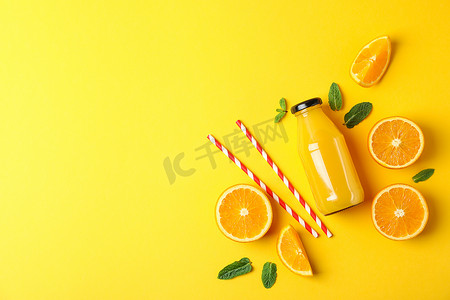 瓶中装有橙子、小管和橙汁的平躺式组合物，文字空间。