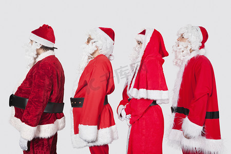 背景鼠年摄影照片_身着圣诞老人服装的人在灰色背景下排成一排